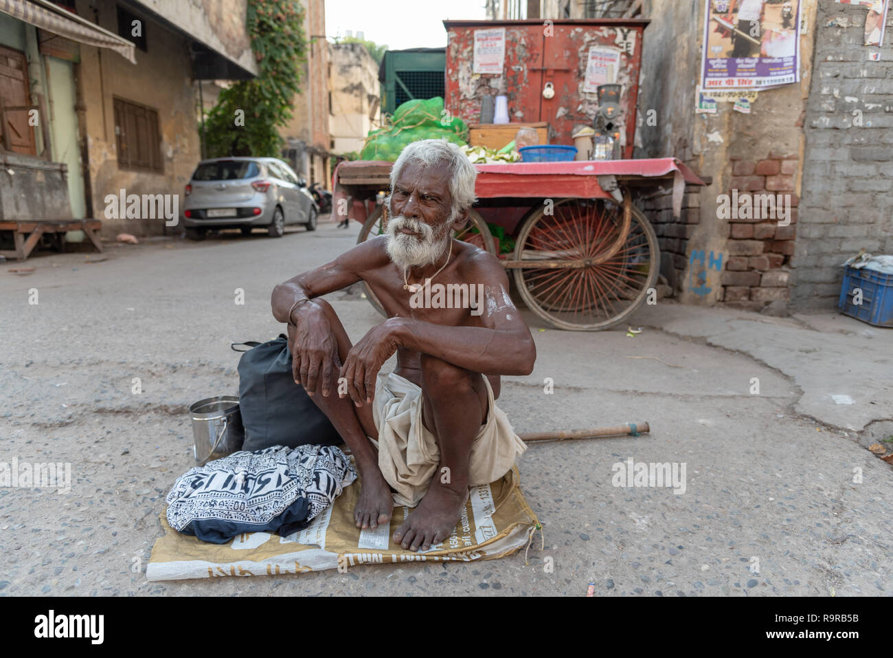 Mendiant indien. Le vieil homme s'est assis sur un sac pour demander des alms, New Delhi, INDE Banque D'Images