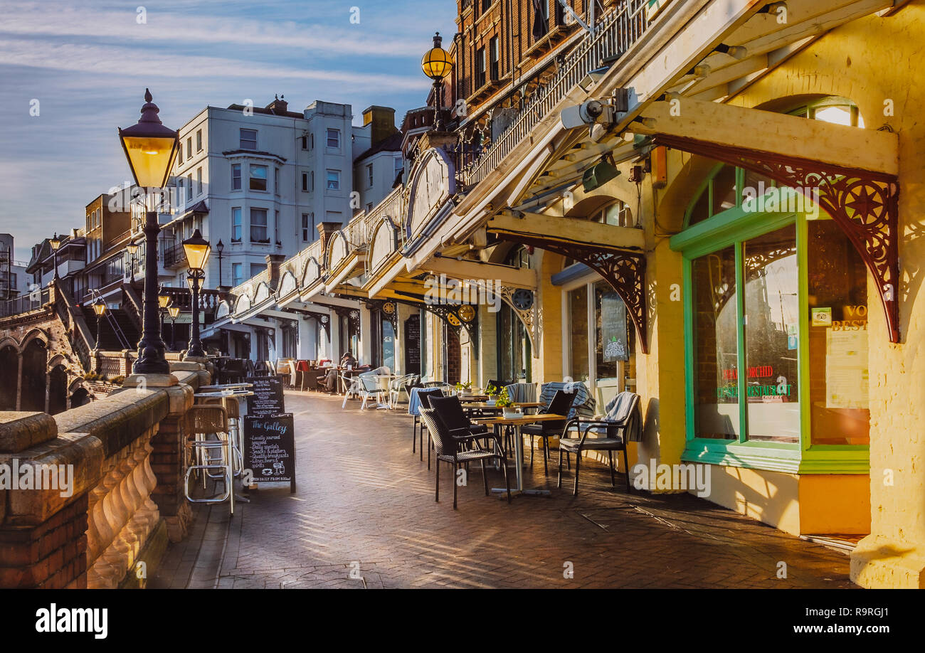 Ramsgate, UK - Dec 24 2018. Le faible soleil d'après-midi illumine les cafés et restaurants le long de la falaise Ouest arcade qui surplombe le Royal Harbour Banque D'Images