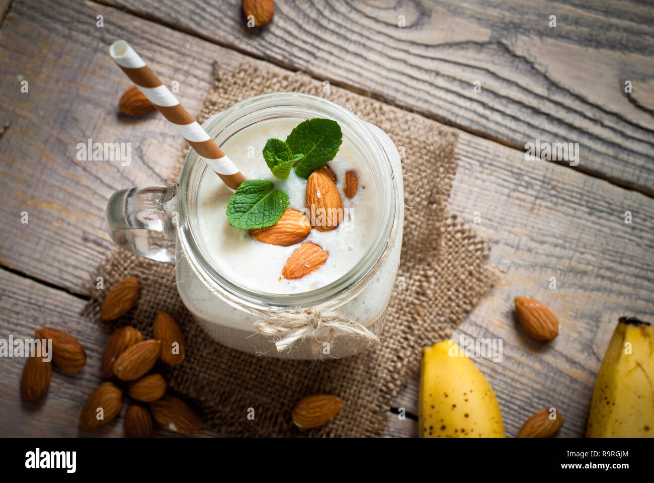 Shake à partir de lait d'amande, de banane et de noix de coco dans un mug mason. Sans produits laitiers. Banque D'Images