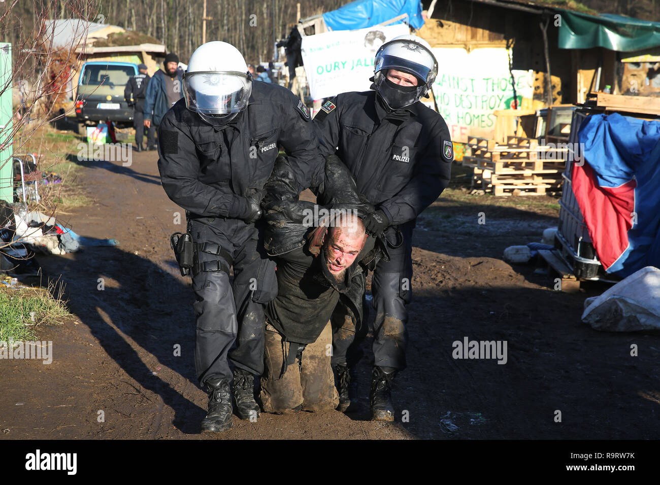 Hambach, Allemagne. 28 Dec, 2018. Les policiers prendre un homme à l'écart dans la soi-disant pré camp. Après plusieurs incidents à la forêt de Hambach, la police a fouillé la soi-disant pré camp des opposants de lignite sur 28.12.2018. Un porte-parole de la police à Aix-la-Chapelle a dit que la recherche était sur des cocktails Molotov ou coupe-boulons ainsi que pour les moyens d'assembler des dispositifs incendiaires. (Dpa 'Razzia à la forêt de Hambach après les incidents de Noël' du 28.12.2018) Crédit : David Young/dpa/Alamy Live News Banque D'Images