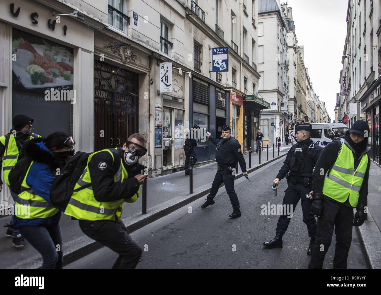 Paris, Ile de France, France. Dec 22, 2018. Un policier vu jeter une grenade lacrymogène à la jaune manifestants pendant la manifestation.gilet jaune les manifestants ont parcouru les rues de Paris un autre samedi sur ce qu'ils appelaient la loi VI contre le président français Emanuelle Macron. Crédit : Bruno Thevenin/SOPA Images/ZUMA/Alamy Fil Live News Banque D'Images