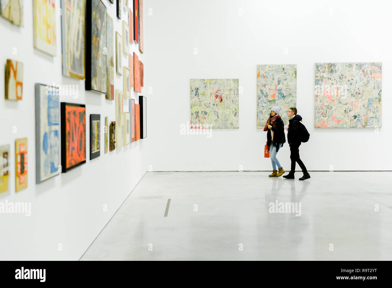 Cracovie, Pologne. 28 Dec, 2018. Un couple vu marcher devant des oeuvres de Boris Lurie Pop-art après l'Holocauste de l'exposition. Boris Lurie (1924-2008) est un artiste américain d'origine juive qui est né à Leningrad (aujourd'hui Saint-Pétersbourg). En août 1941, les Allemands commencèrent à expulser la population juive locale au ghetto de Riga, où Boris Lurie a passé son enfance. Sa grand-mère, mère, sœur et bien-aimé ont été tournées dans une forêt proche d'Rumbuli dans la banlieue de Riga en décembre 1941. Son travail est étroitement lié à cette expérience au cours de l'Holocauste. Les motifs figurant dans ses oeuvres Banque D'Images