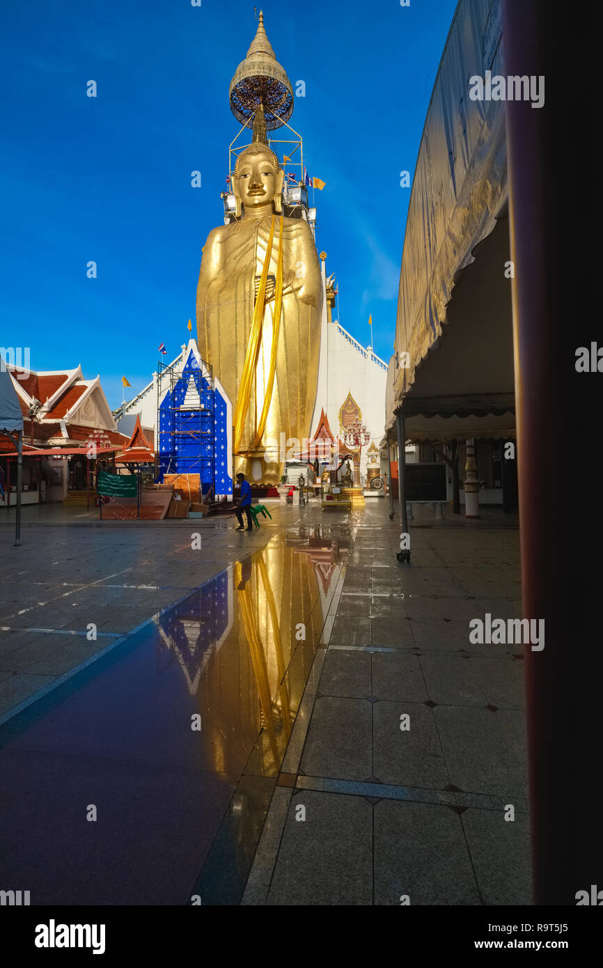 Le comité permanent de Bouddha géant Wat Intharaviharn Indraviharn () à Bangkok, Thaïlande, le figure reflétée sur la surface du sol à l'avant Banque D'Images