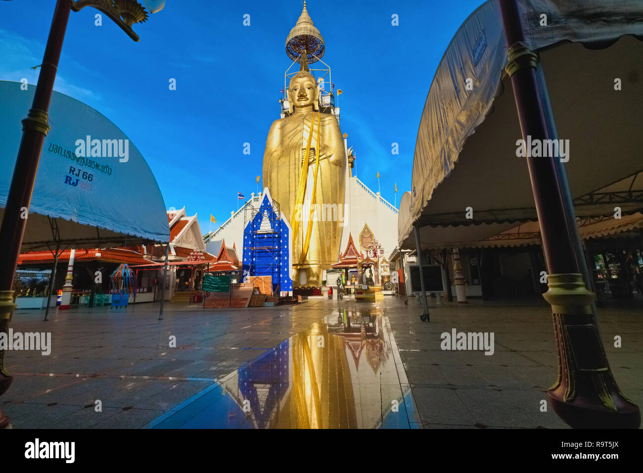 Le comité permanent de Bouddha géant Wat Intharaviharn Indraviharn () à Bangkok, Thaïlande, le figure reflétée sur la surface du sol à l'avant Banque D'Images