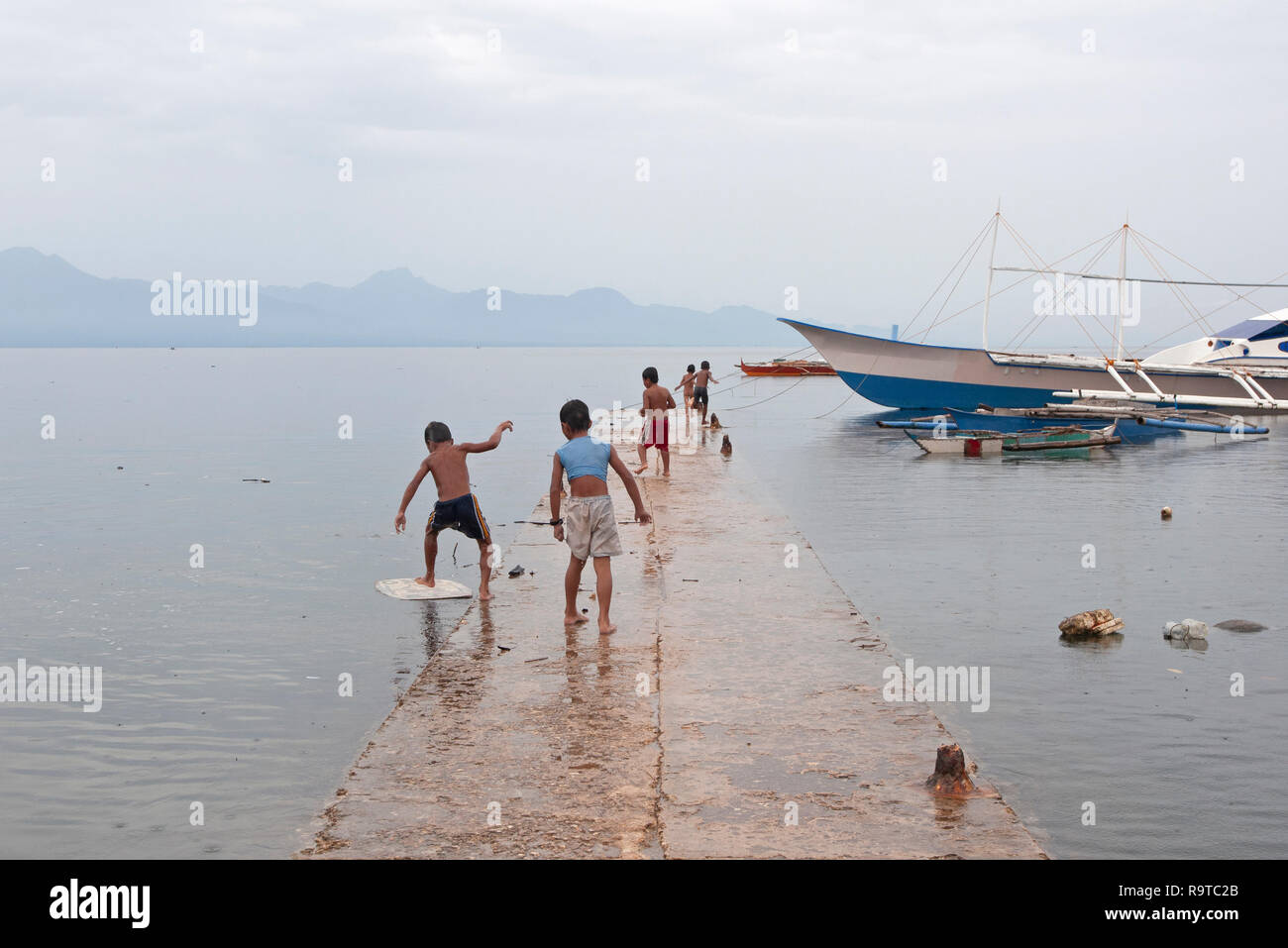 Les enfants jouent et nager à Tambisan Pier, près de l'île de San Juan, Sequijor, Visayas, Philippines, Asie du Sud, Asie Banque D'Images