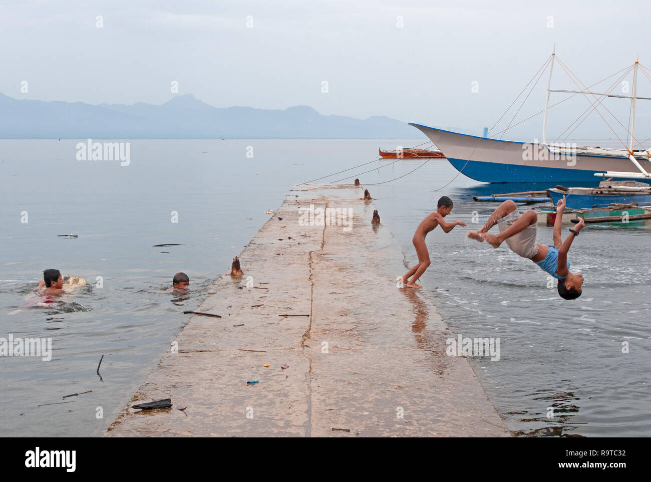 Les enfants jouent et nager à Tambisan Pier, près de l'île de San Juan, Sequijor, Visayas, Philippines, Asie du Sud, Asie Banque D'Images