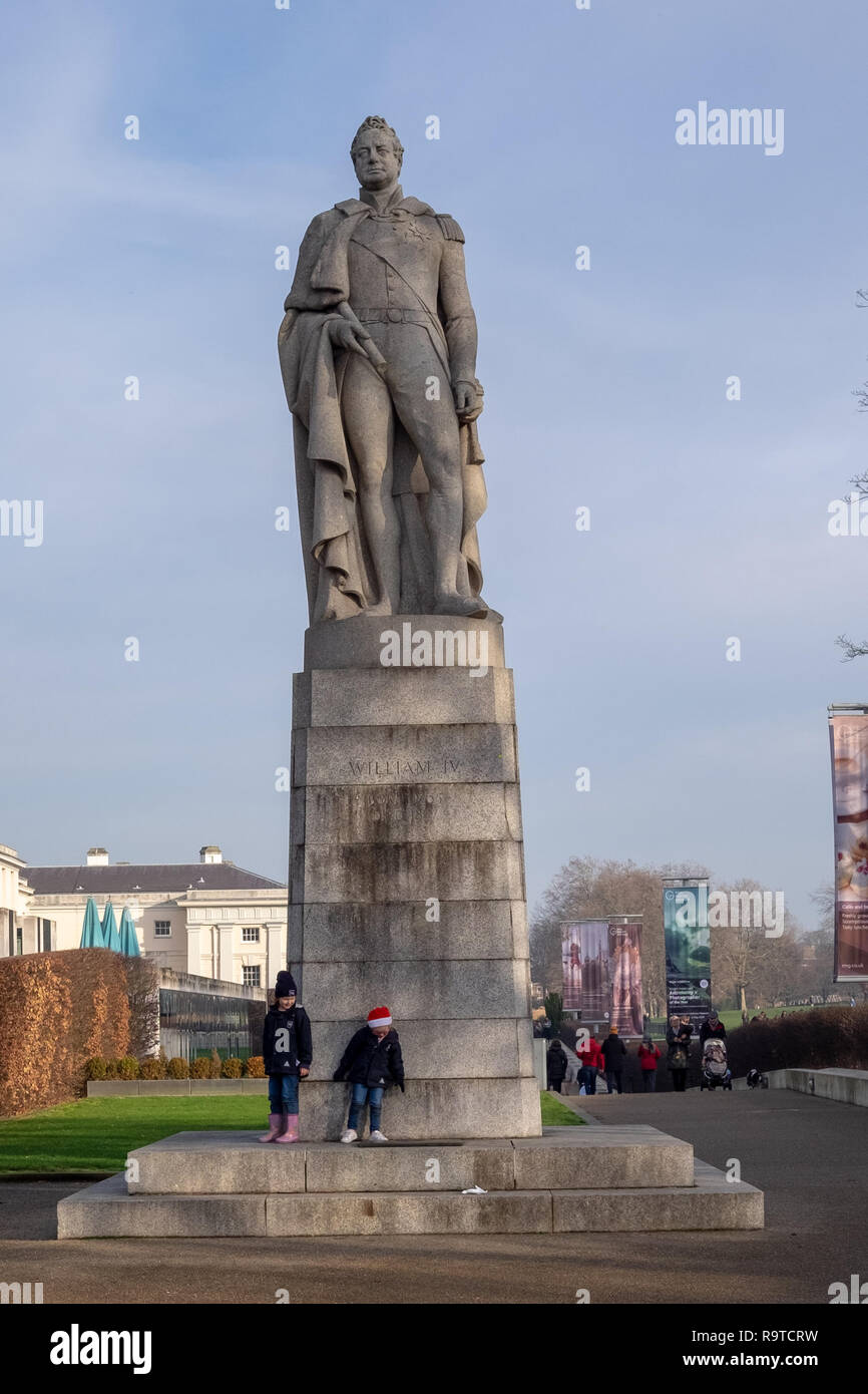 Deux enfants jouent au pied d'un état historique de King William IV près de Greenwich Park et le National Maritime Museum. Banque D'Images