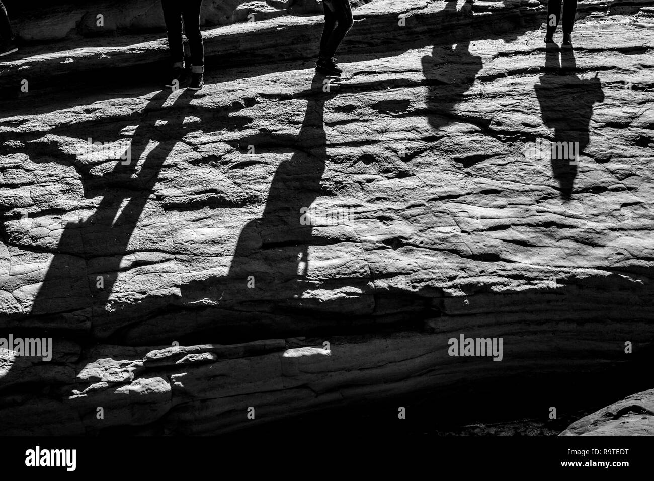 Ombres de quatre jeunes contre le soleil sur la mer immense falaise à Love Canal, à Corfou, l'île de Kerkira, Grèce en journée de printemps ensoleillée Banque D'Images