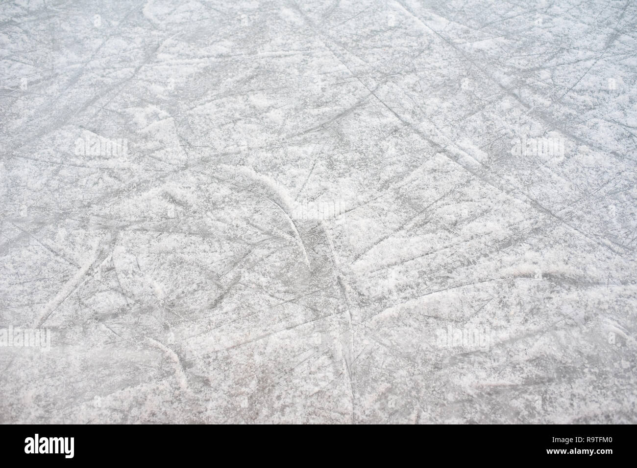 Arrière-plan de plancher d'une patinoire avec des marques de skate, avec du blanc de la neige durant l'hiver. Banque D'Images