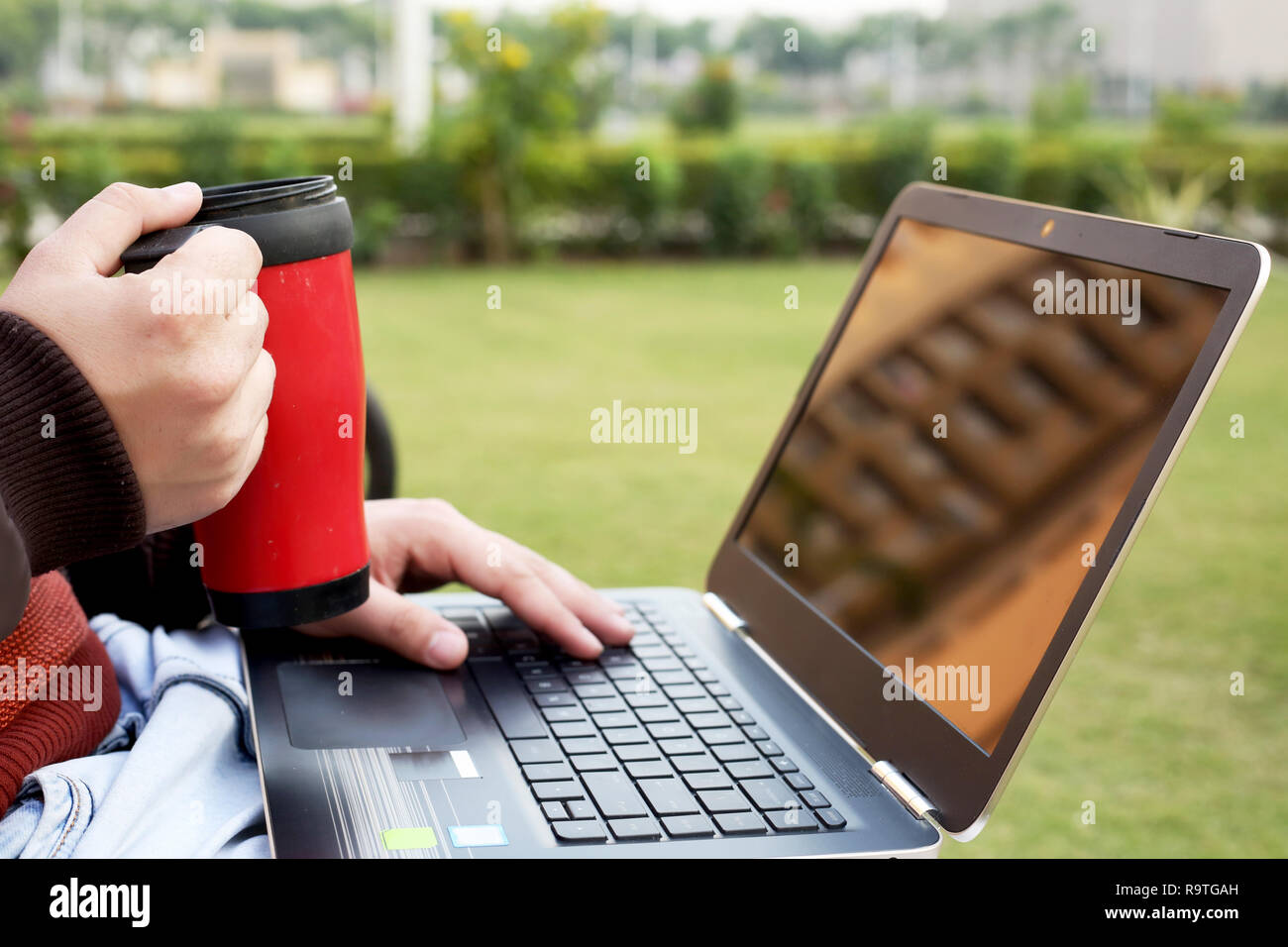 Boy est holding water bottle in hand with laptop Banque D'Images