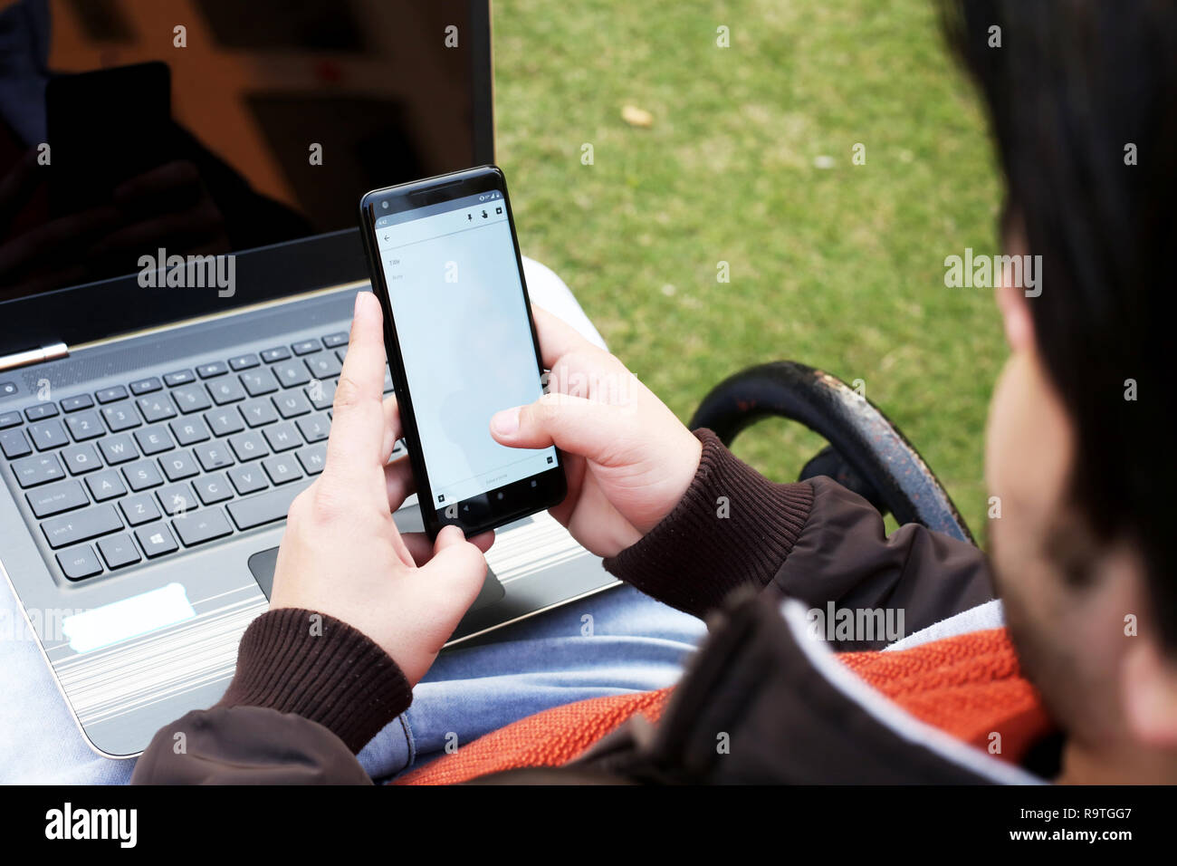 Photo de l'homme est l'utilisation de smartphone avec ordinateur portable. Banque D'Images