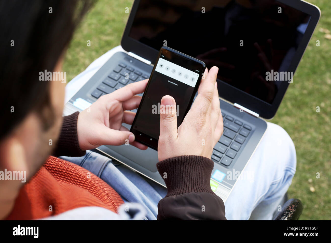 L'homme est de travailler sur le smartphone avec ordinateur portable. Banque D'Images