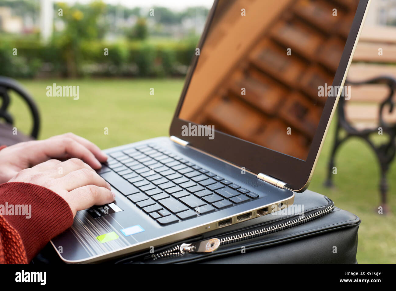 Jeune homme travaille sur l'ordinateur portable en parc. Banque D'Images