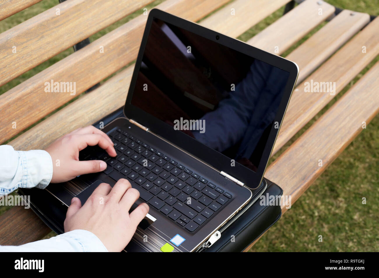 Jeune homme travaille sur l'ordinateur portable en parc. Banque D'Images
