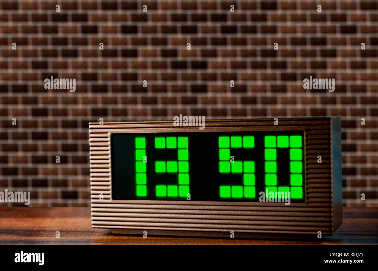 Horloge électronique sur la surface sur un mur de briques texture background Banque D'Images