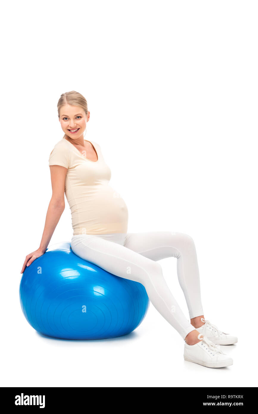 Enceinte blonde woman sitting on fitness ball isolated on white Banque D'Images
