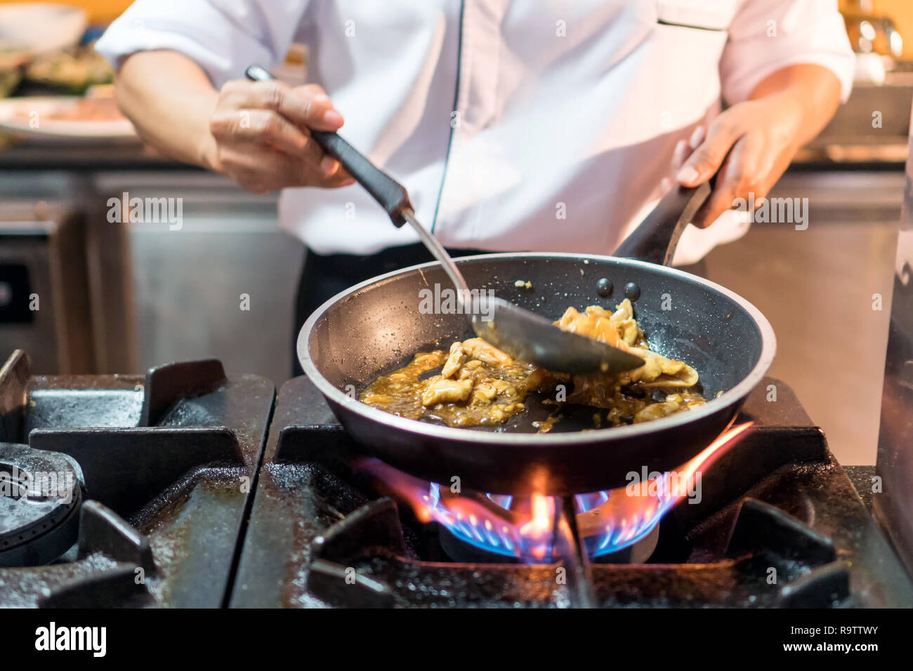 Cuisson des aliments thaïlandais Chef de Cuisine poêle à feu flammes sur Cuisinière à gaz Banque D'Images