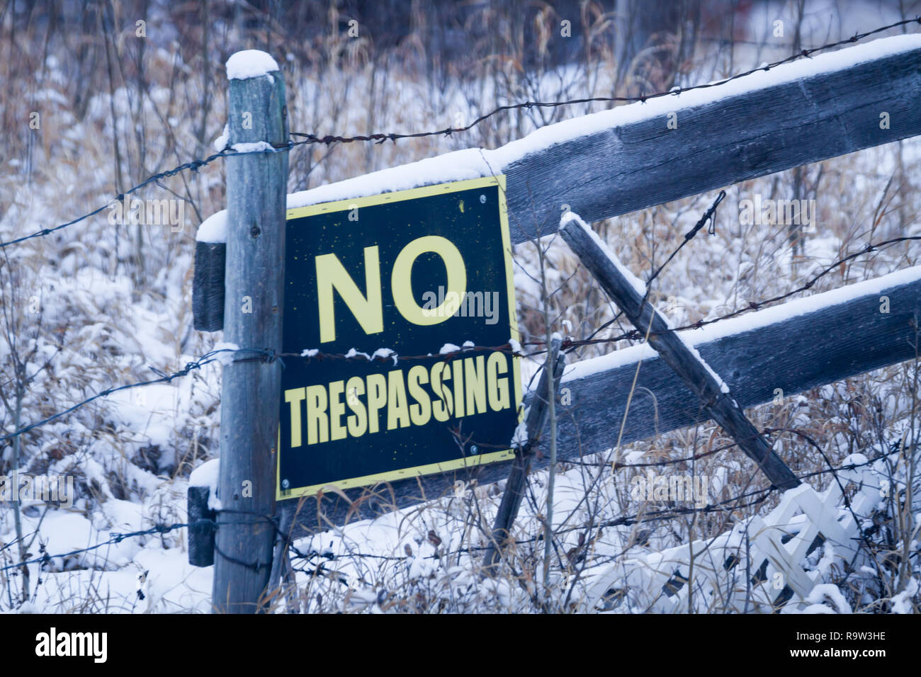 La criminalité en milieu rural sont à la hausse dans les régions rurales de l'Alberta, Canada. Ici, le propriétaire foncier a posté une entrée interdite signe sur bois et barbelés. Banque D'Images