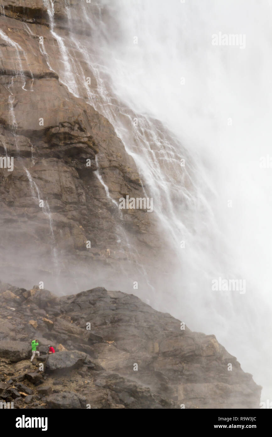 2 personnes se rapprocher de la brume des chutes Takakkaw, une cascade spectaculaire, situé dans le parc national Yoho (Canadian Rockies), British Columbia, Canada. Banque D'Images