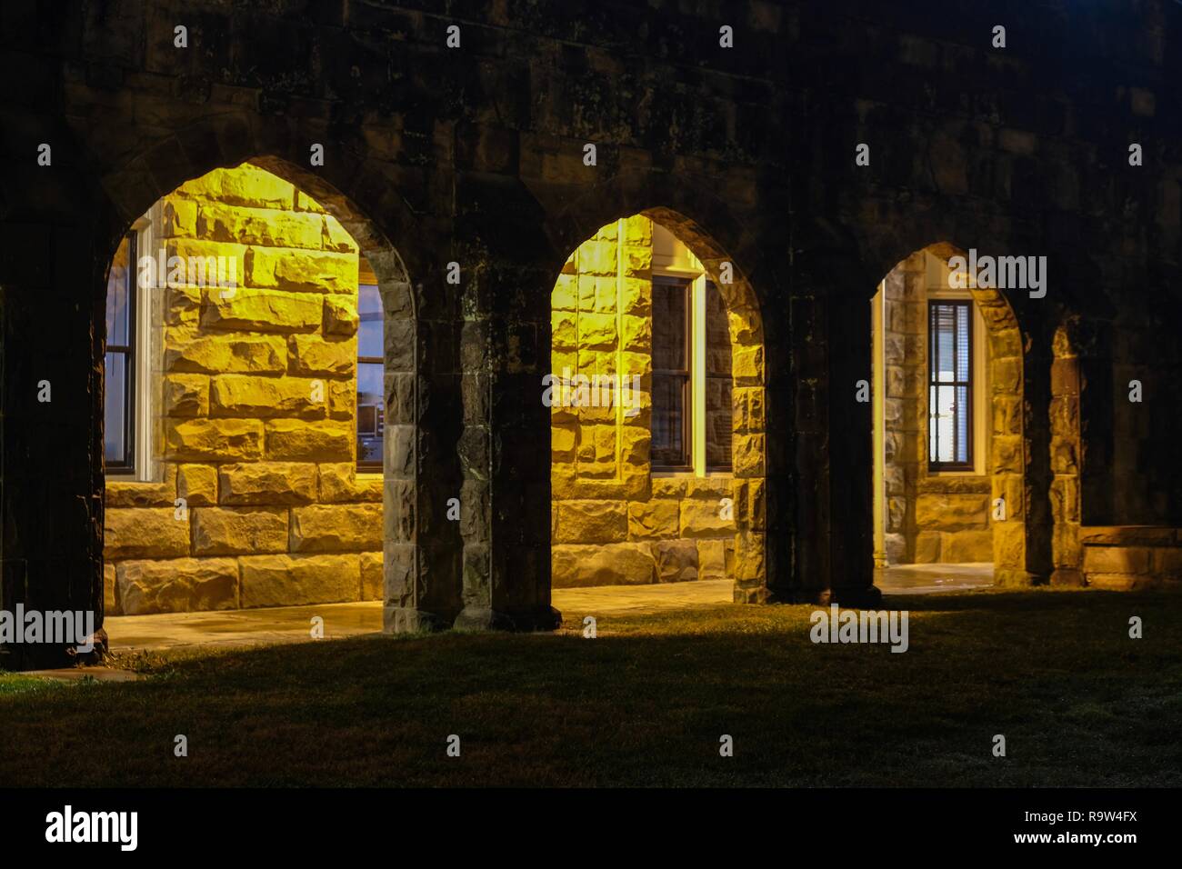 Vue nocturne de l'extérieur d'un passage voûté faiblement éclairé de la chapelle de Tous les Saints à l'Université du Sud à Sewanee, Tennessee. Banque D'Images