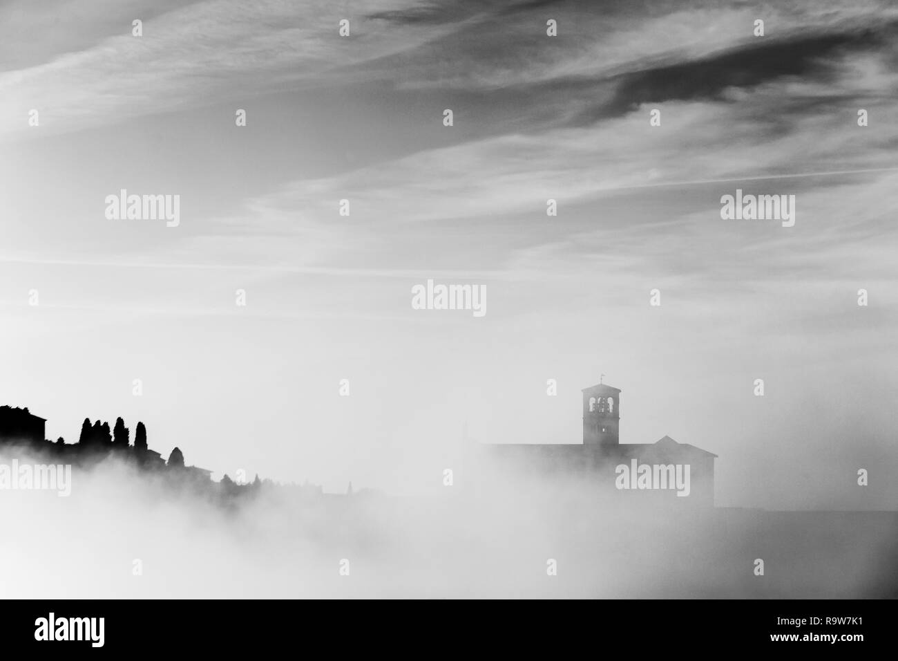 Vue d'une silhouette de l'église Saint-François d'assise au milieu de la brume sous un ciel profond avec des nuages Banque D'Images