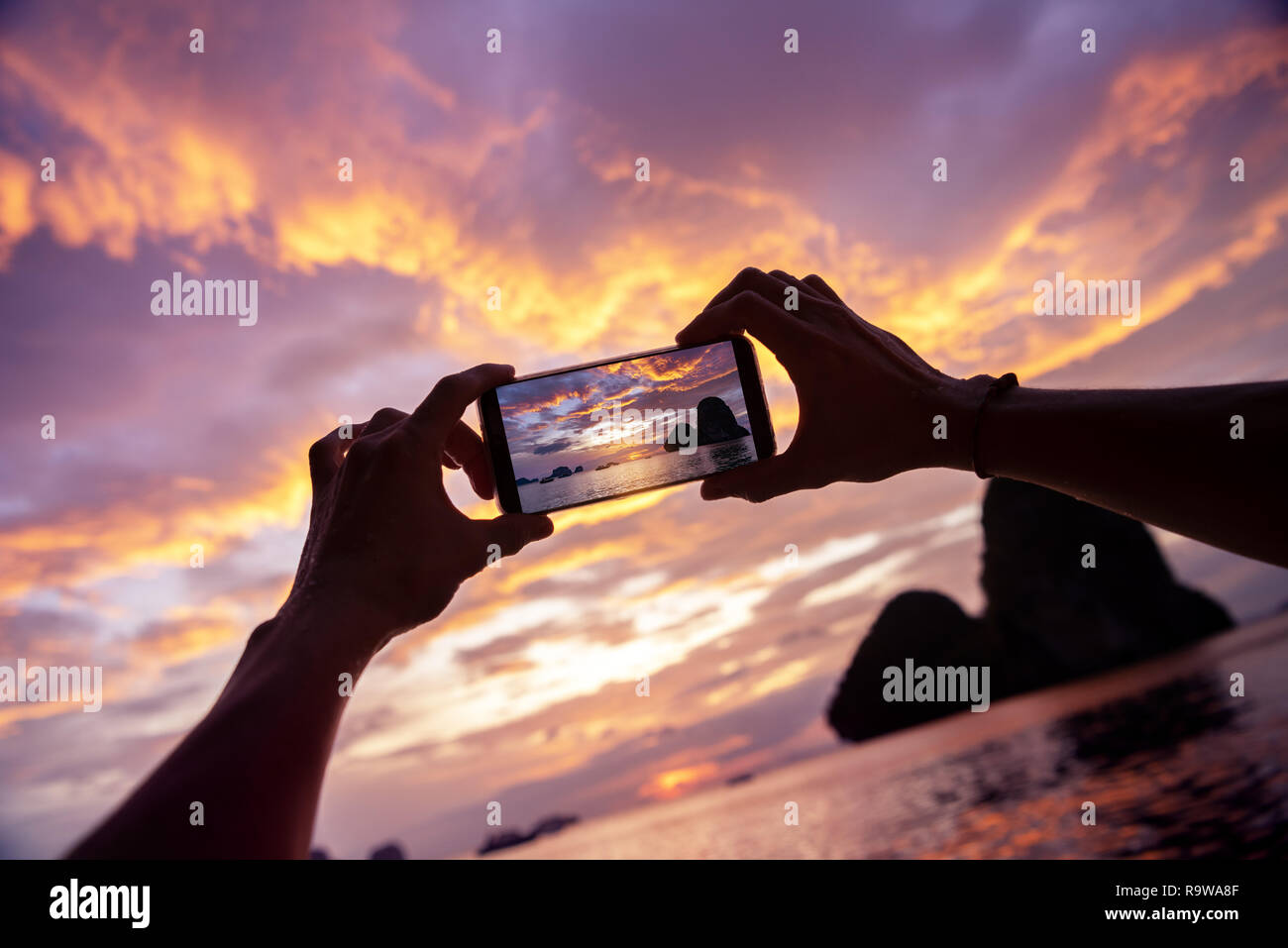 Photo gros plan de mains en prenant une photo de téléphone mobile. La province de Krabi, Railay Beach sur l'arrière-plan Banque D'Images