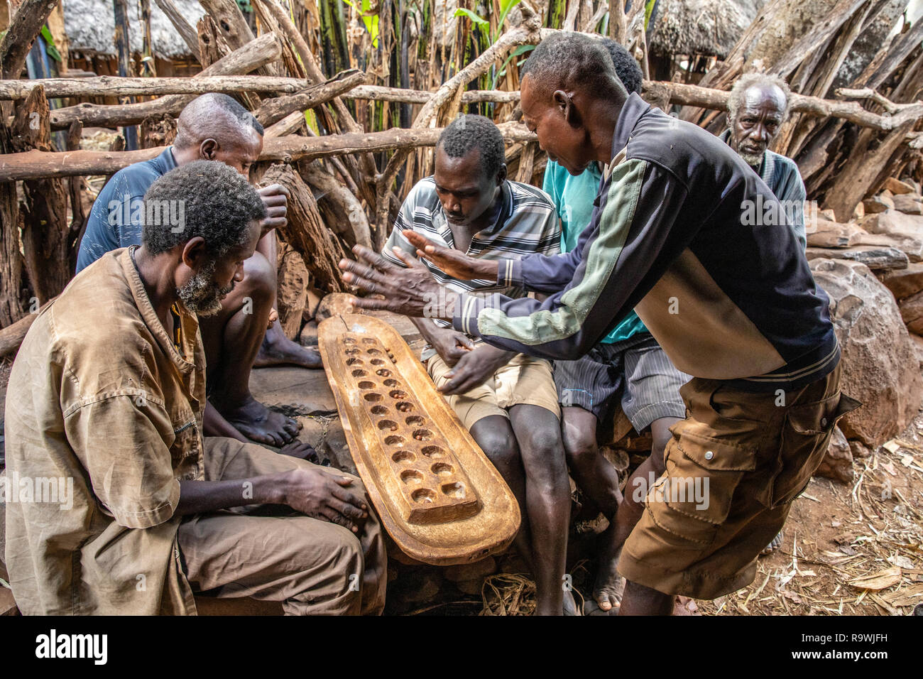 Tribu Konso lecture Gebeta, le plus ancien jeu de plateau, vallée de l'Omo, Ethiopie Banque D'Images