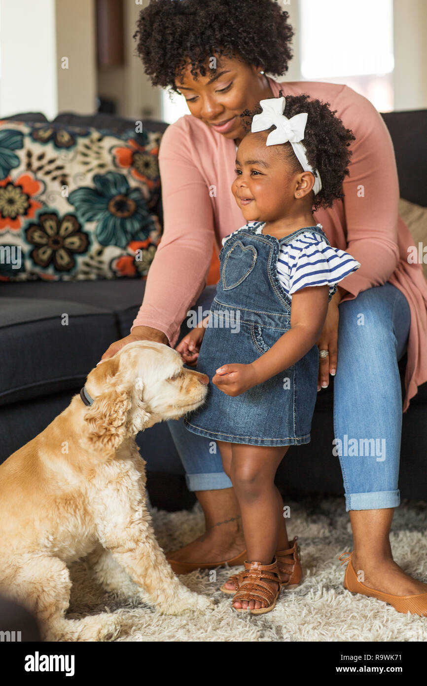 Petite fille et sa maman jouer avec leur chien. Banque D'Images