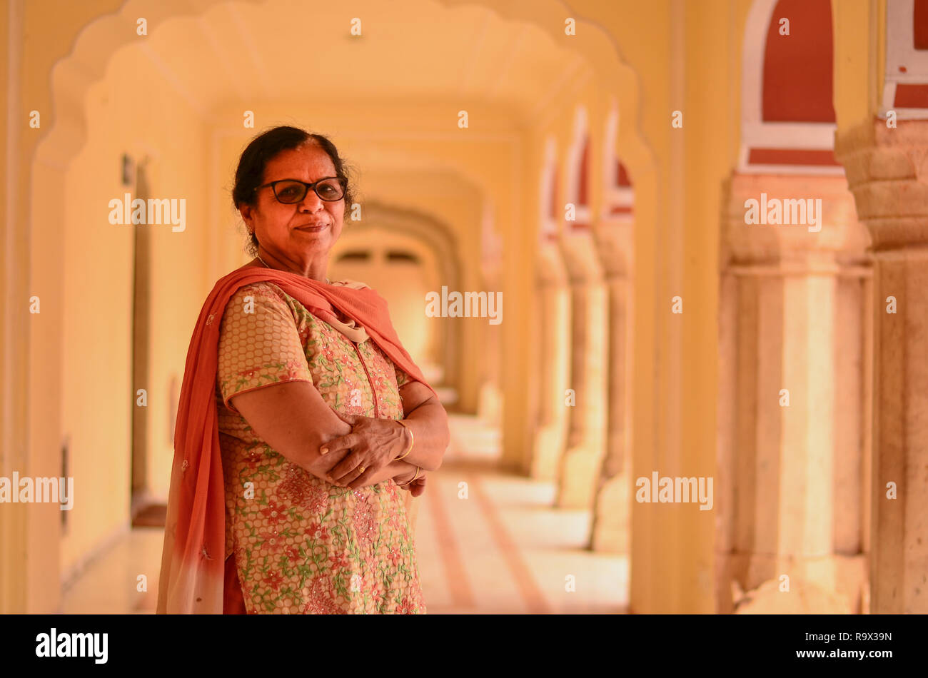 Professionnels à la recherche de vêtements traditionnels indiens senior dame répondre à poser dans le couloir de la palais de la ville. Banque D'Images