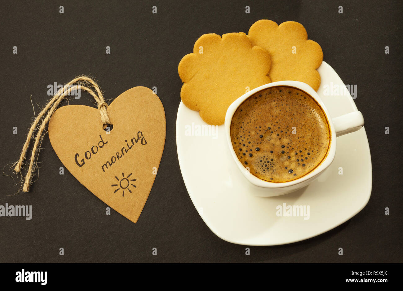 Du café noir et des cookies sur fond sombre petit-déjeuner Banque D'Images