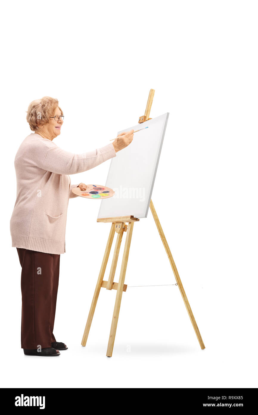 Tourné sur toute la longueur d'un senior woman painting on canvas isolé sur fond blanc Banque D'Images