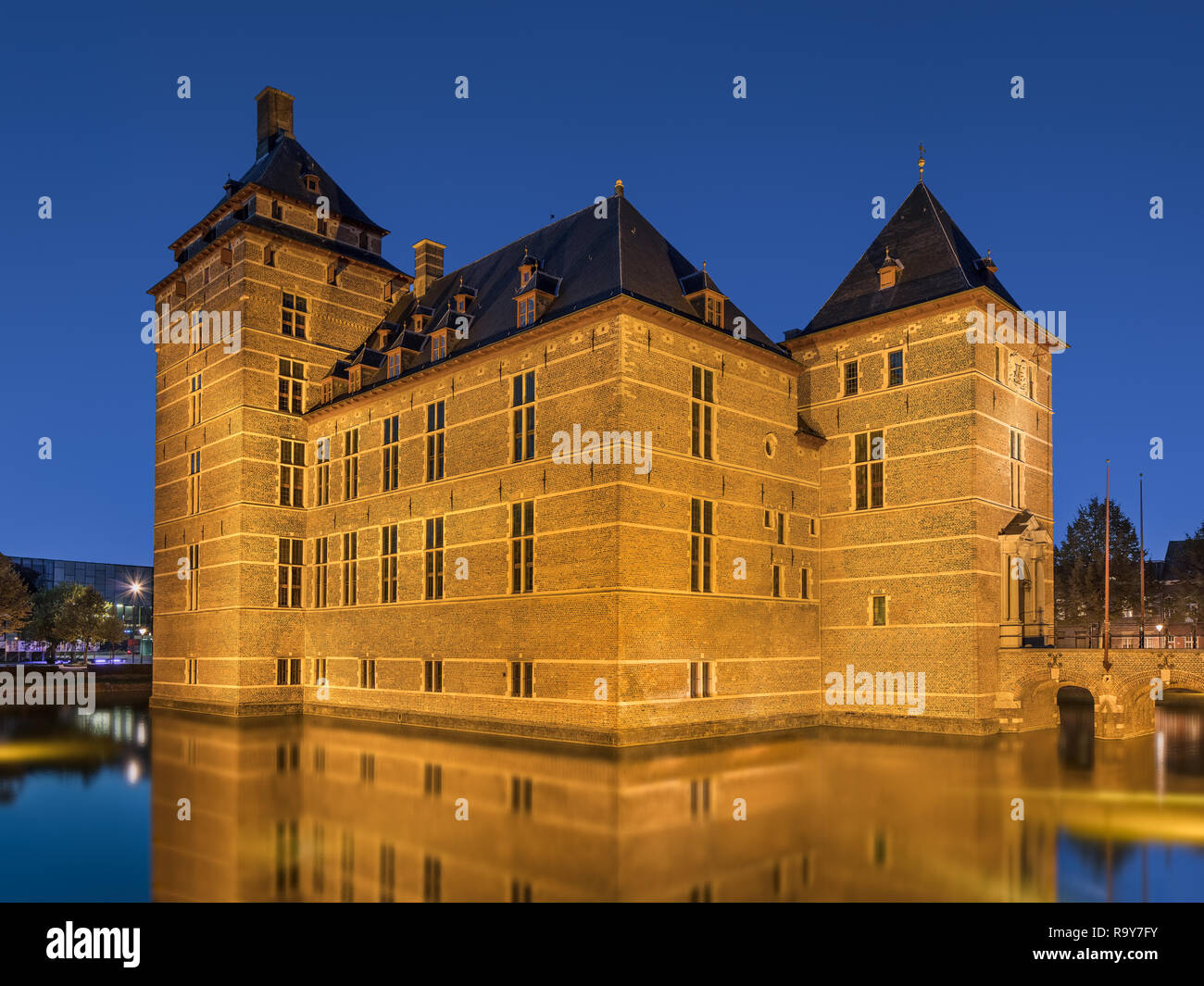 Allumé en 12ème siècle rénové château entouré d'eau au crépuscule, l'Europe. Banque D'Images