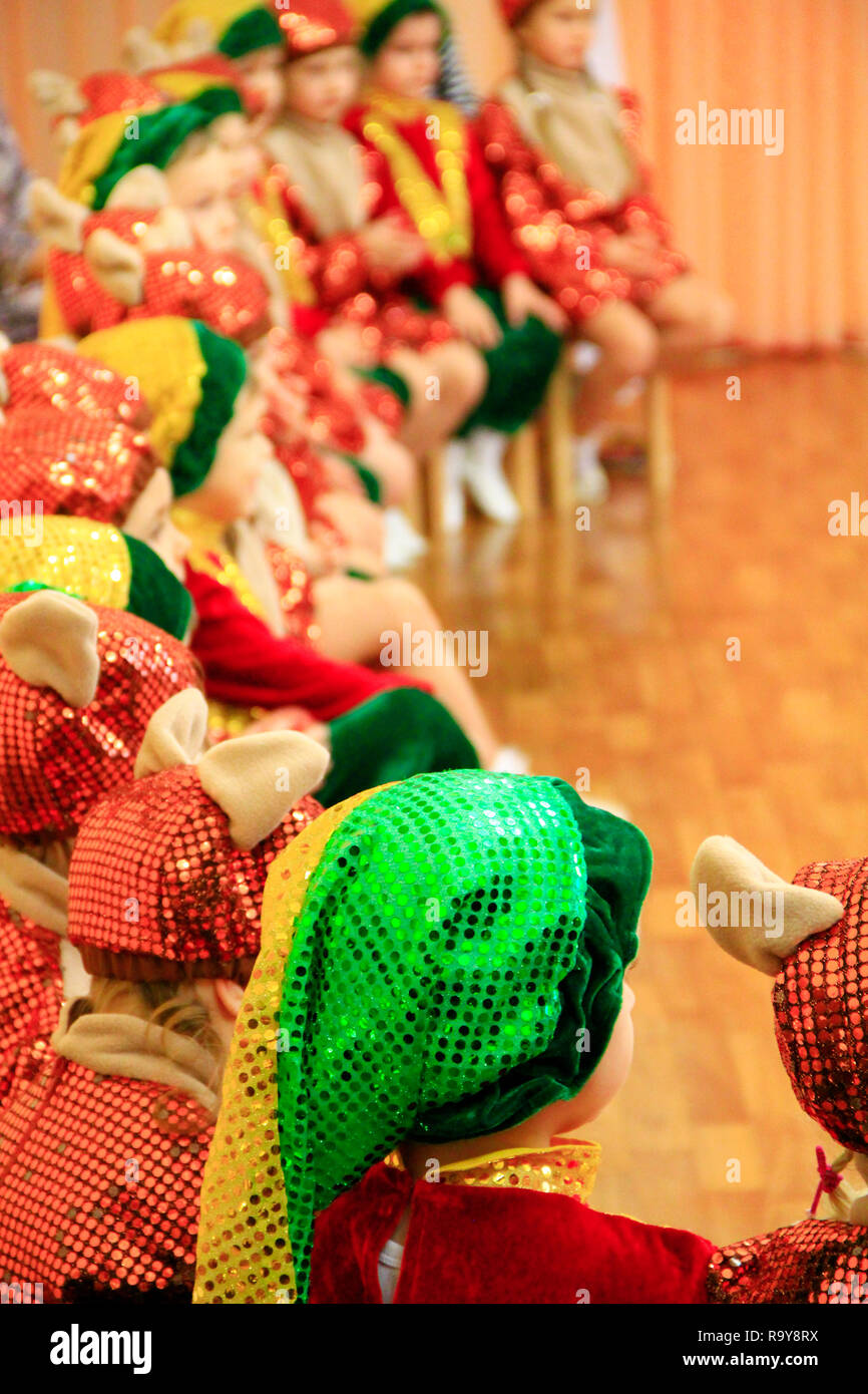 Les enfants en robes de fantaisie sur matinee à la maternelle. Les enfants en costumes smart s'asseoir sur des chaises au cours de la performance à la maternelle en matinée Banque D'Images