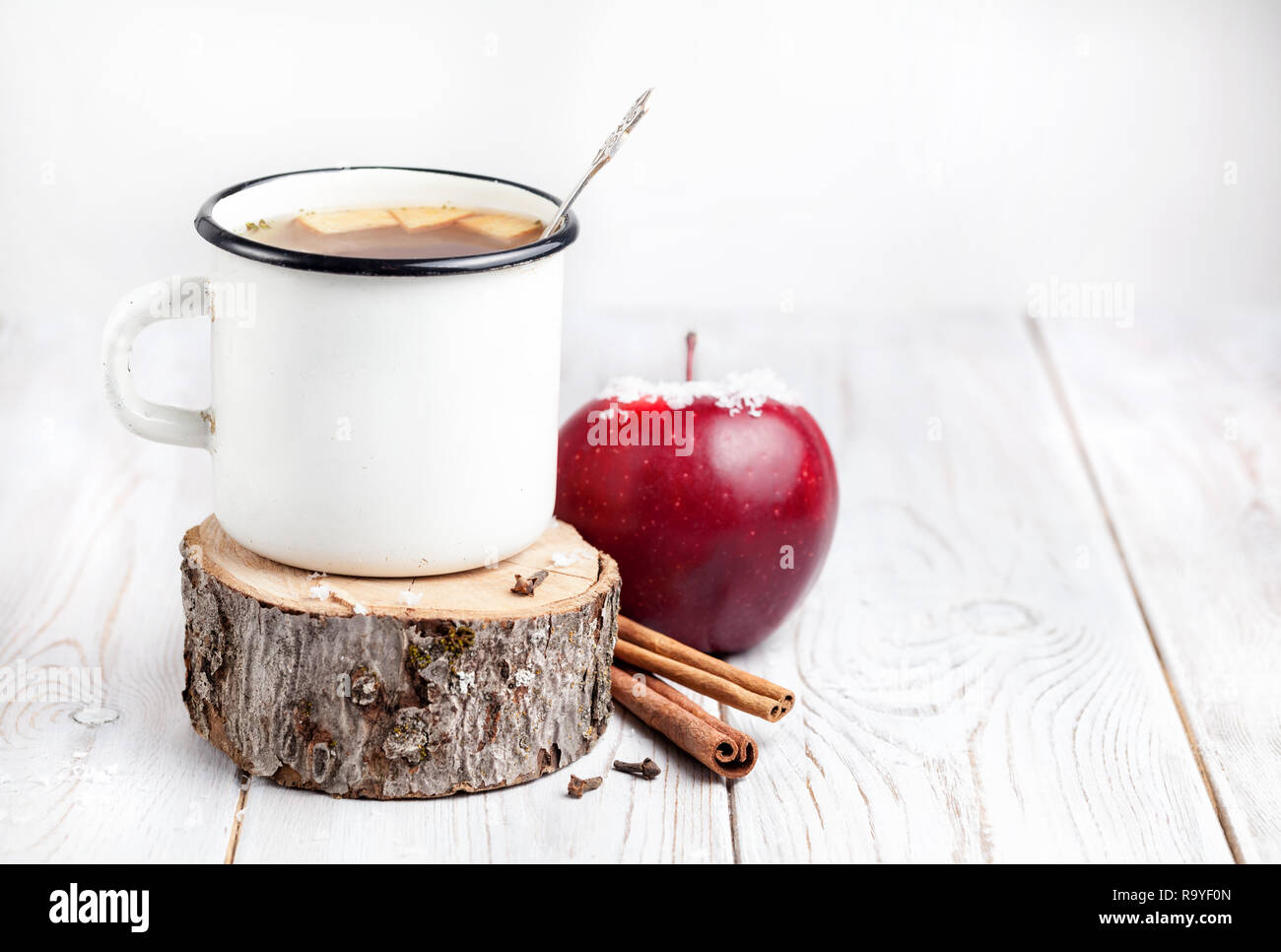 Boisson chaude à partir de pommes et d'épices sur fond de bois blanc à l'époque de Noël Banque D'Images