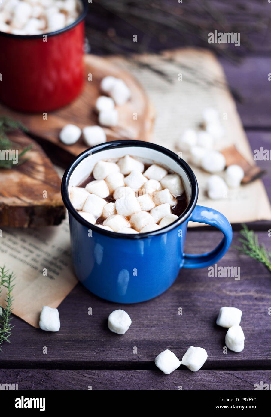 Le cacao avec des guimauves en bleu et rouge café sur table en bois en hiver Banque D'Images