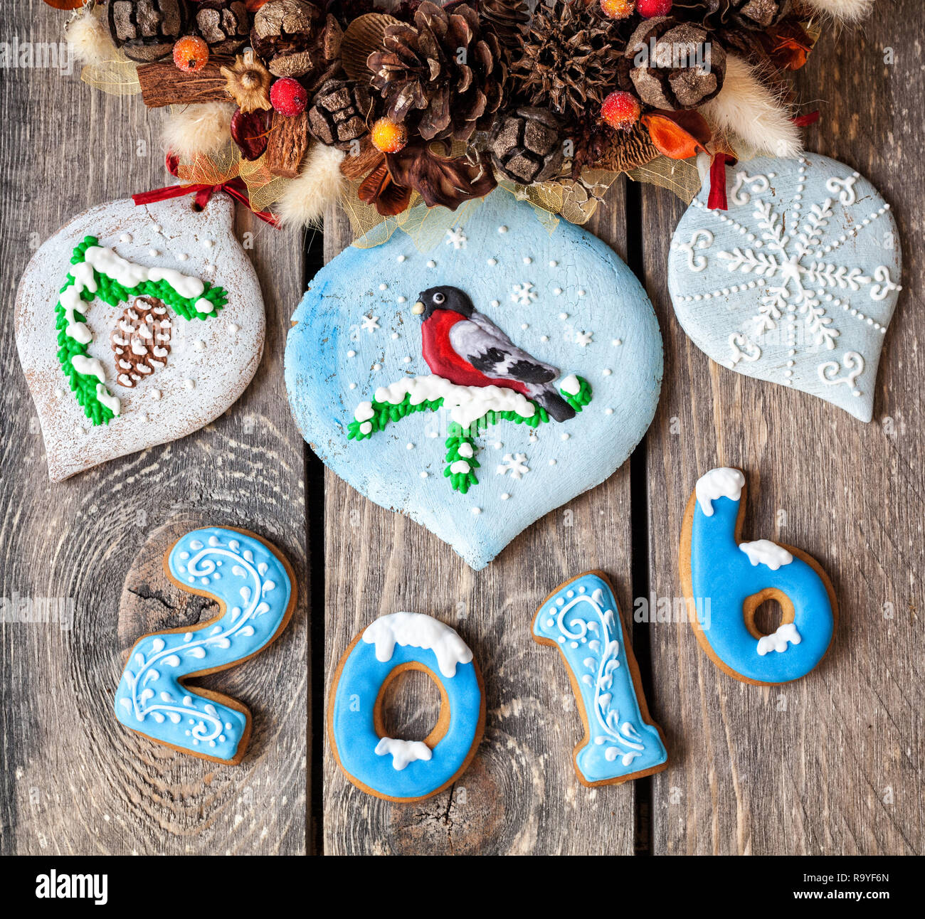 L'année 2016 et d'épice de Noël jouets doux sur des oiseaux près de Noël à manger sur fond de bois Banque D'Images