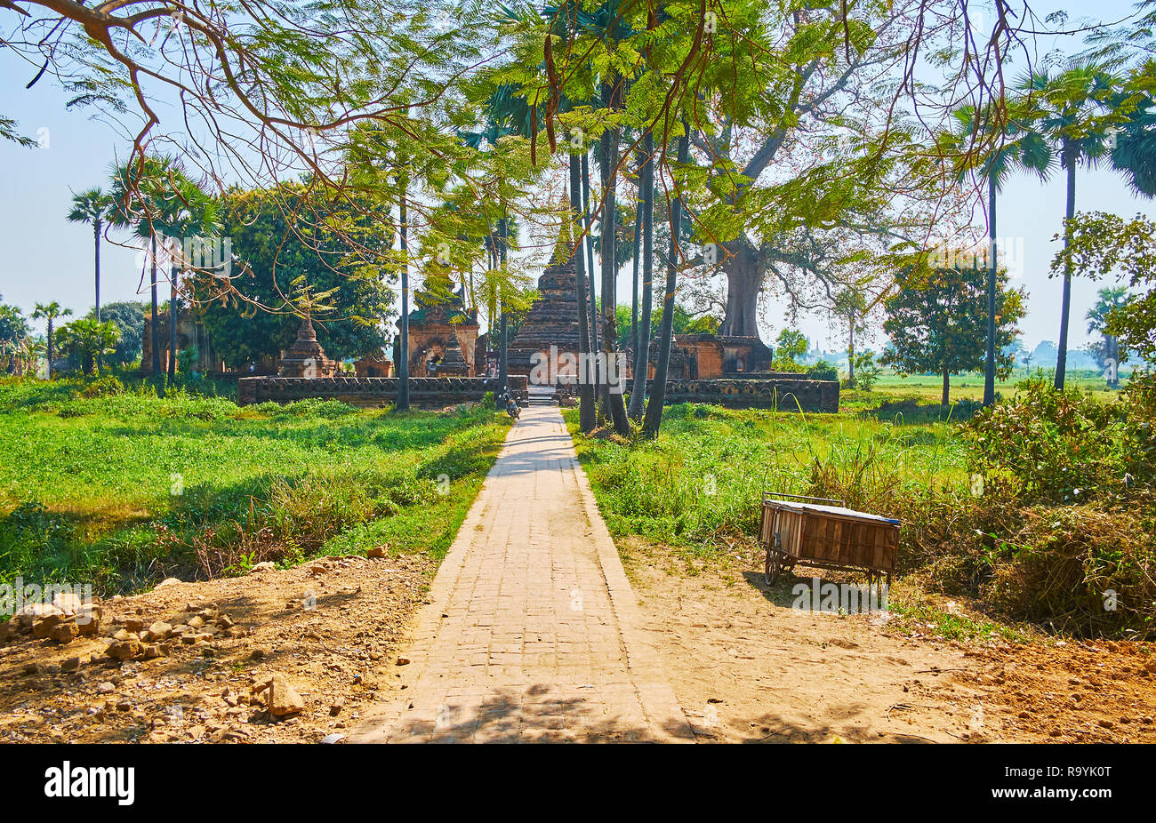 La luxuriante verdure tropic masque le Yandana Sinme ancienne pagode en brique rouge, entouré de terres agricoles et de champs peddy, Ava (Inwa), le Myanmar. Banque D'Images
