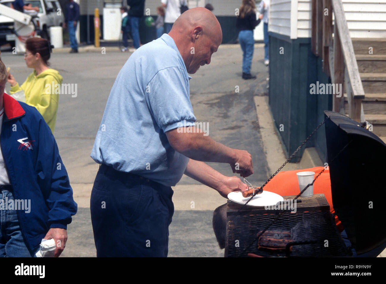 Man grilling hamburgerss et hot-dogs Banque D'Images
