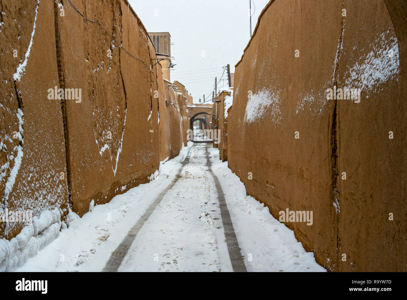 Une chute de neige légère couvrant une grande paroi murale ruelle étroite de Yazd, Iran. Banque D'Images