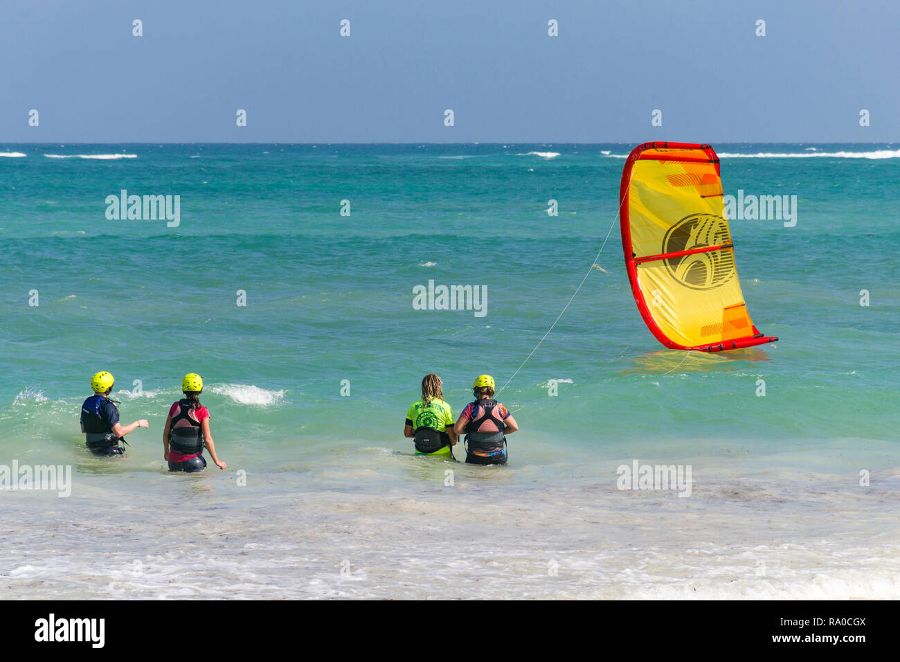 Les touristes avec l'apprentissage de l'instructeur de kitesurf dans l'océan Indien par la plage de sable blanc, Diani, Kenya Banque D'Images