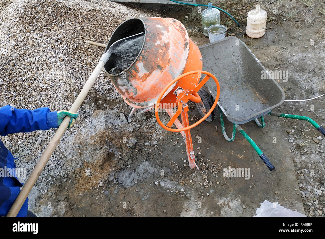 Travailleur auxiliaire utilise une pelle pour préparer un mortier de ciment  sur un chantier de construction 2018 Photo Stock - Alamy