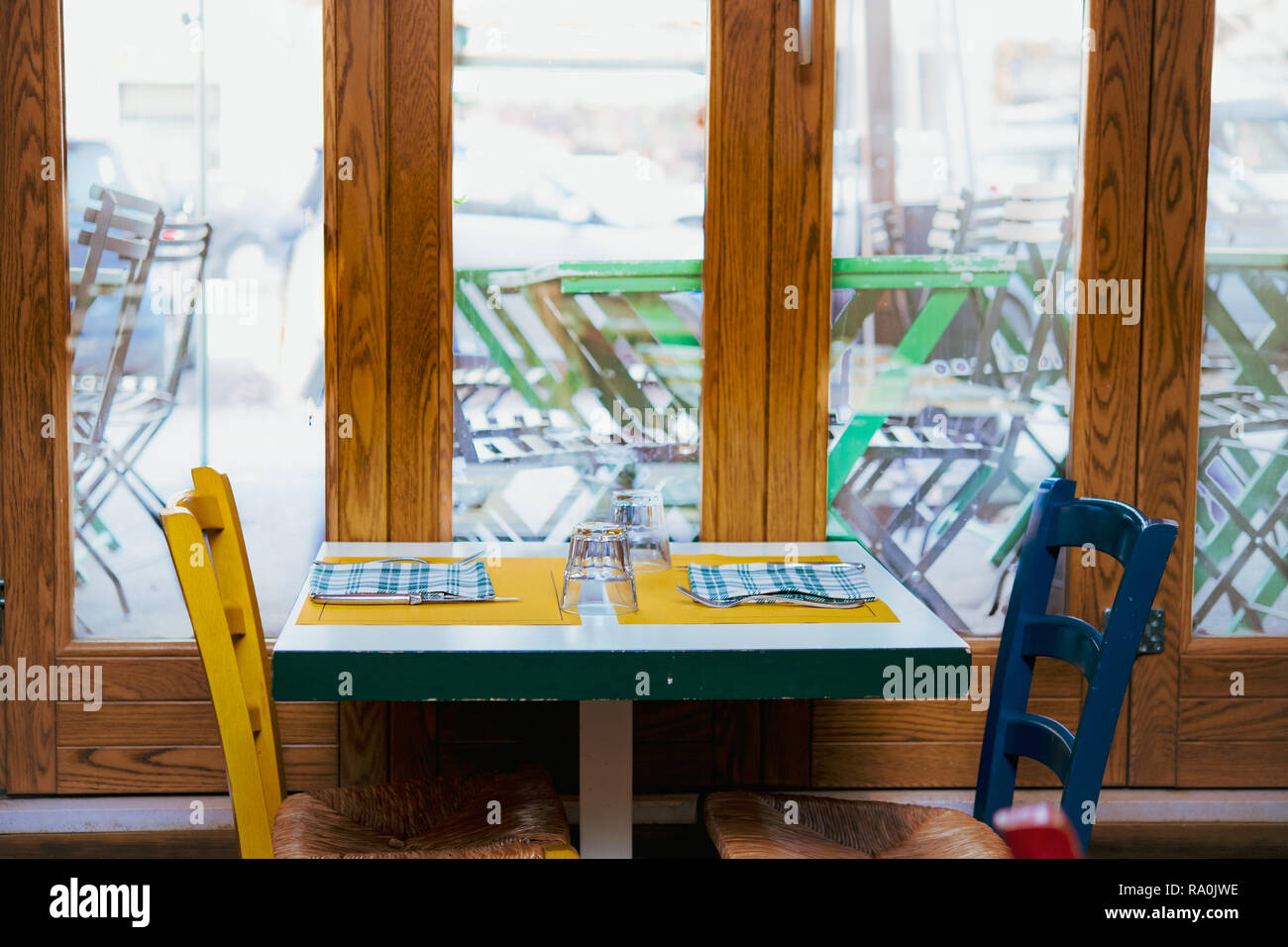 Set de table pour deux personnes, pas de restaurant rustique, mobilier de style pays multicolores, grande fenêtre en arrière-plan Banque D'Images