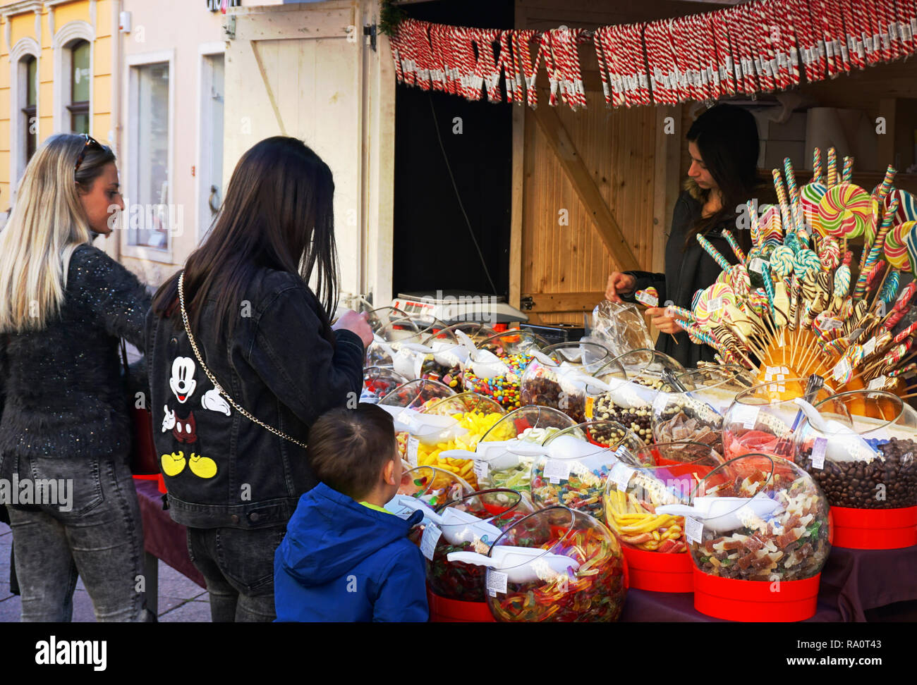 Rijeka, Croatie, 29 décembre 2018. Les jeunes belles filles et un petit garçon acheter des bonbons au stand du marché Banque D'Images