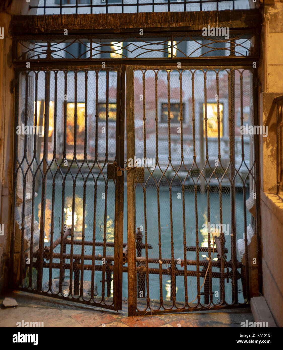 Old palace gates menant au canal, Venice, Italie. Banque D'Images