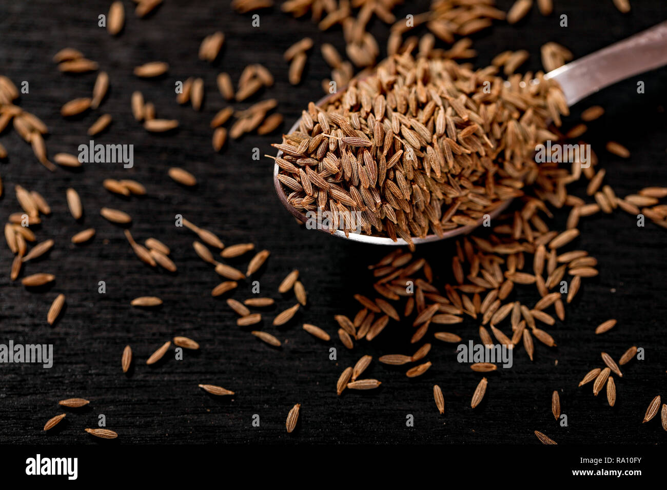 Les graines de cumin sur fond noir Banque D'Images