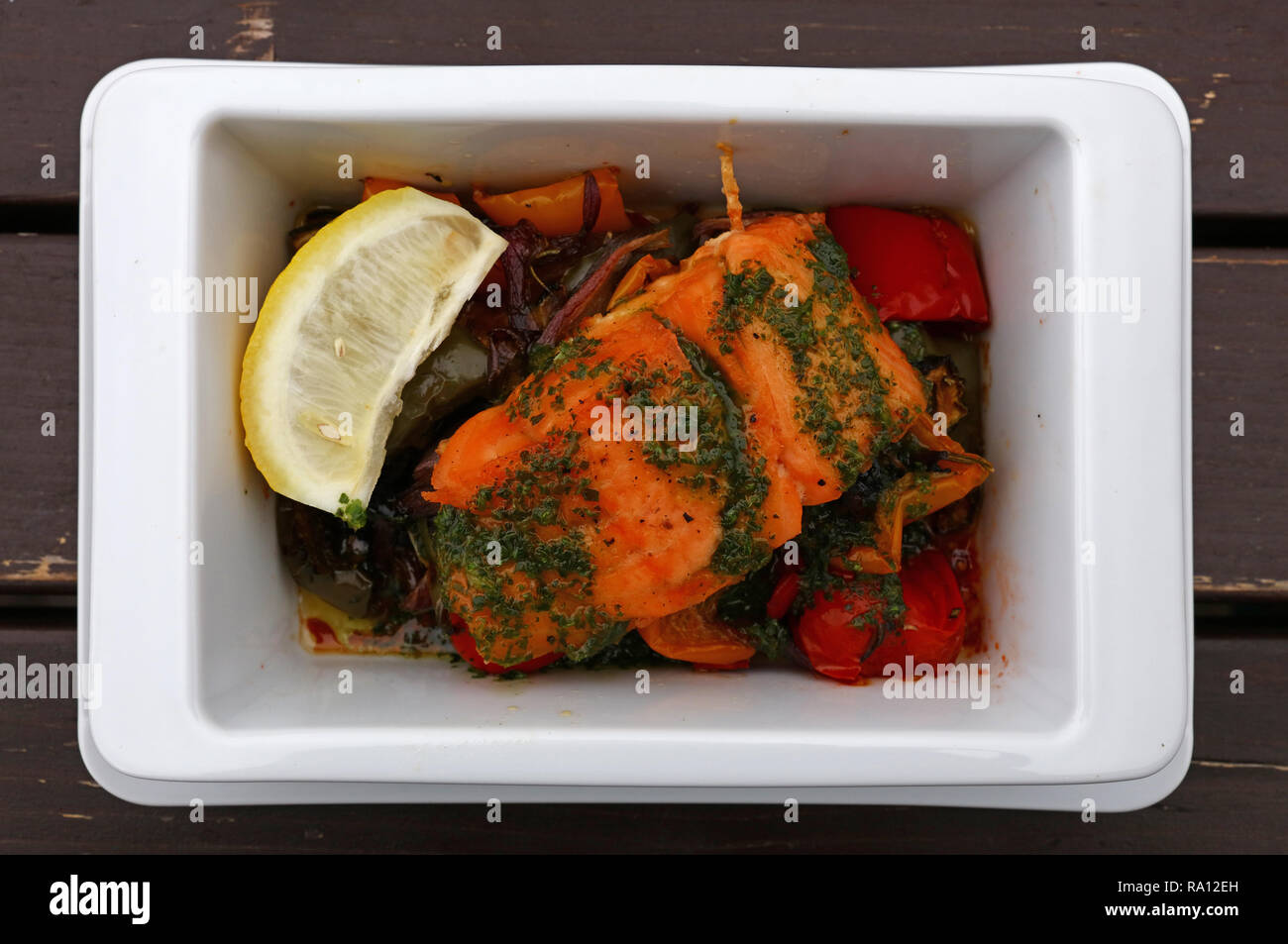 Close up partie de saumon rôti au four ou avec des légumes dans un bol blanc sur le tableau, augmentation de la vue supérieure, juste au-dessus Banque D'Images