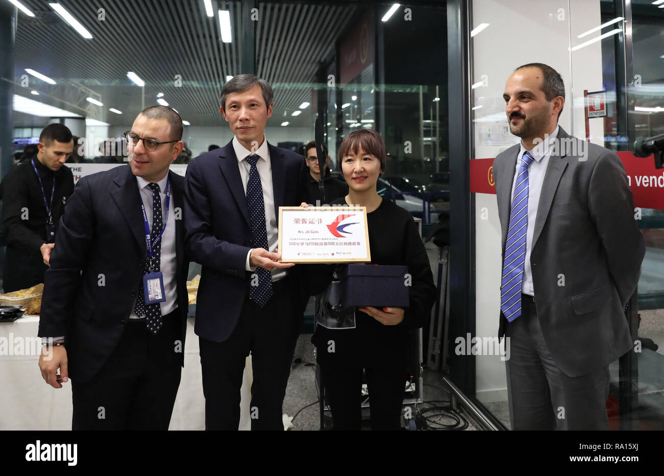 Rome, Italie. 28 Dec, 2018. Voyageurs chinois Jia Guilin (2e R) est accueillie comme la 15 millionième passager de l'aéroport Fiumicino de Rome en 2018, à Rome, la capitale de l'Italie, au 28 décembre 2018. Credit : Cheng Tingting/Xinhua/Alamy Live News Banque D'Images