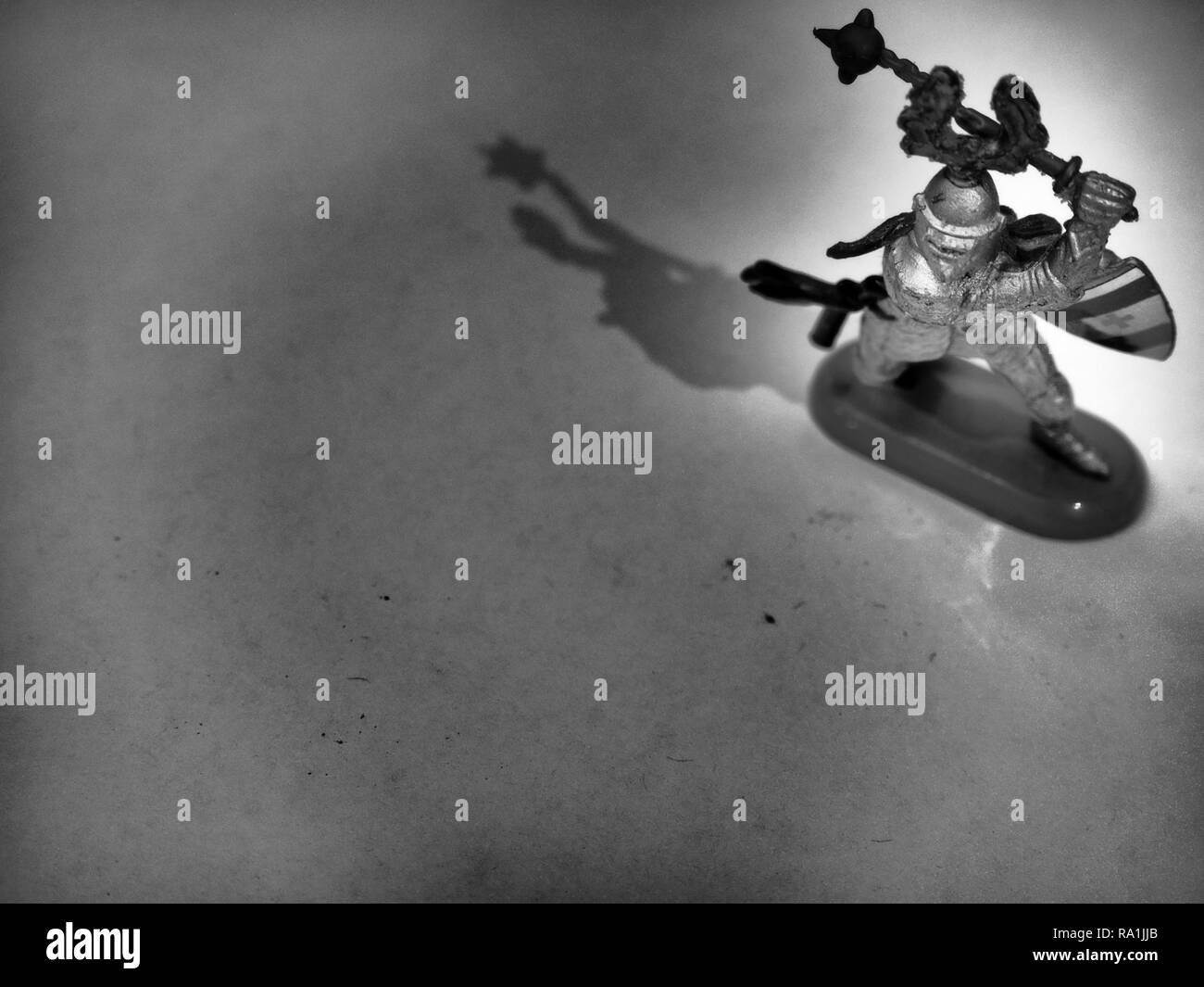 Image en noir et blanc de chevalier brandissant le fléau sur table en bois Banque D'Images