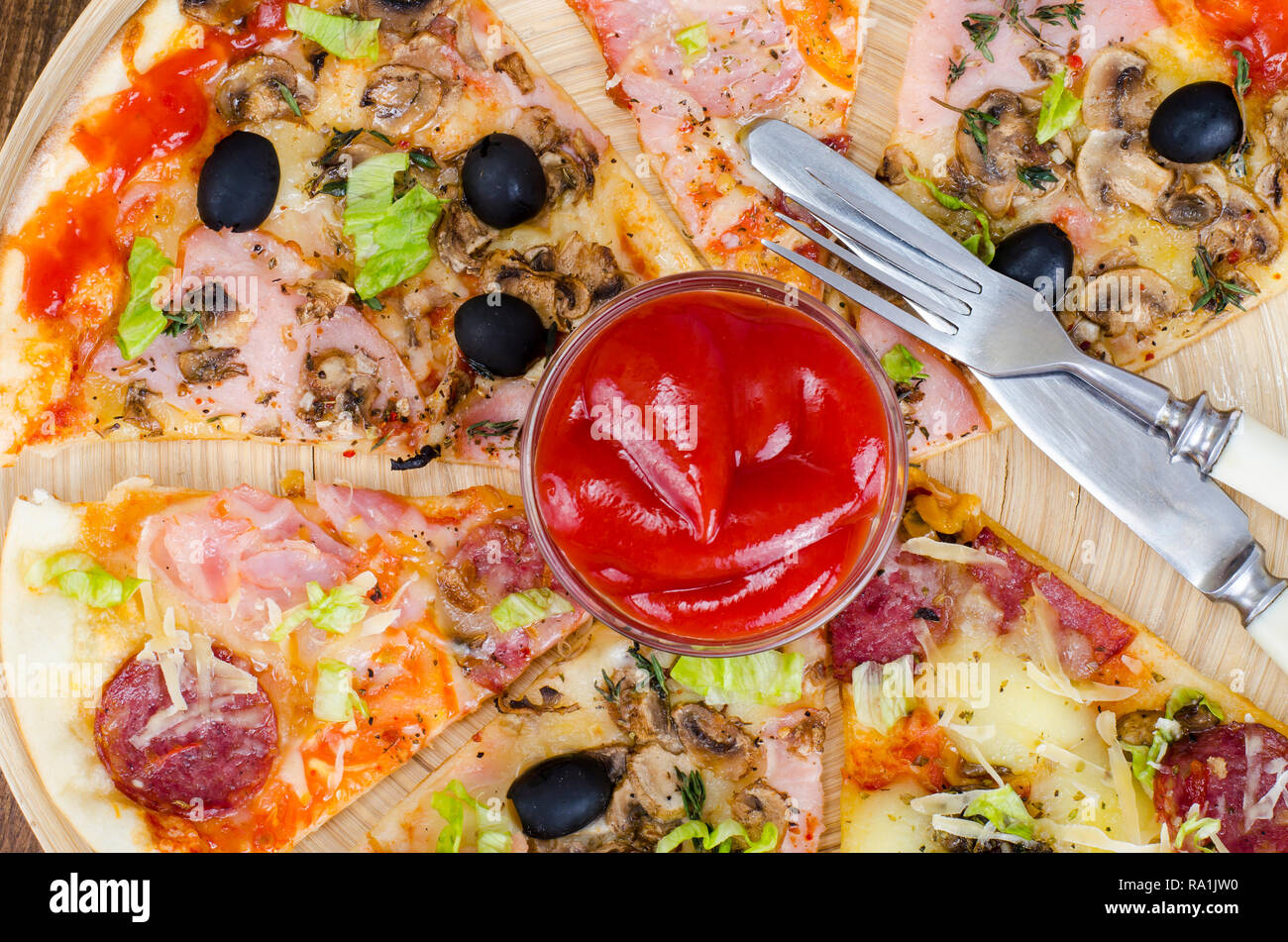 Six tranches de pizza avec des garnitures différentes sur planche de bois. Studio Photo Banque D'Images