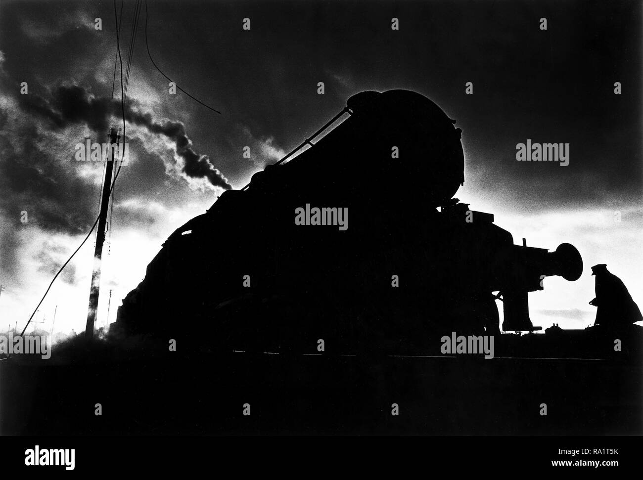 Août 1968, le dernier mois de fer à vapeur en Grande-Bretagne. Carnforth, Lancashire, près de Lancaster. Un pilote de moteur à monter les pistes pour lancer un tour de retard, la conduite d'un train de nuit. Banque D'Images